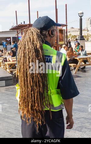 England, London, Southwark, London Bridge City, More London Riverside Offices, Rear View of Security Guard with Long Dreadlocks Hair Stock Photo
