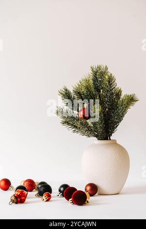 Minimalistic Christmas composition with fir branches in ceramic vase on white background. Front view. Copy space Stock Photo