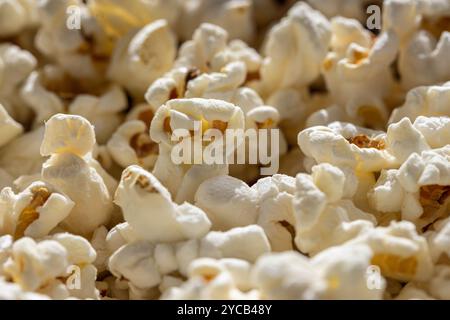 Macro shot of a heap of fluffy, freshly popped popcorn, evoking memories of cozy movie nights and fun at the fair. Stock Photo