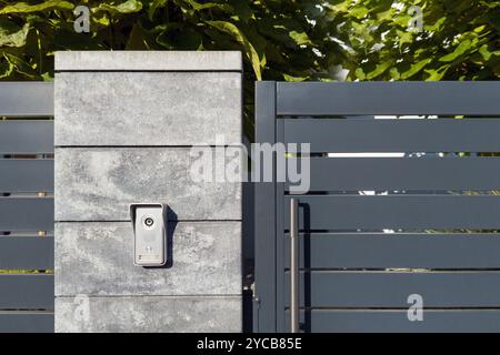 Modern Metal Gate with Intercom on Concrete Pillar Stock Photo