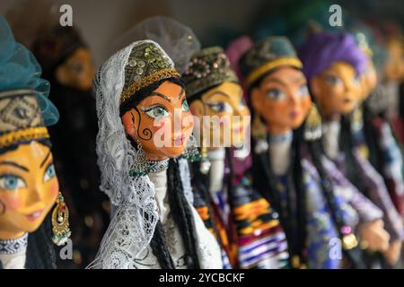 Assortment of handmade Uzbek hand puppets for sale are on the wall of tourist shop in old town of Bukhara Stock Photo