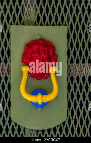 Colorful Door Knocker on Metal Grate Background Stock Photo