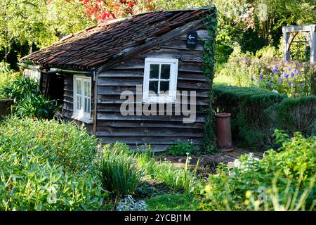 A pretty rustic wooden garden shed in an English Garden. Stock Photo