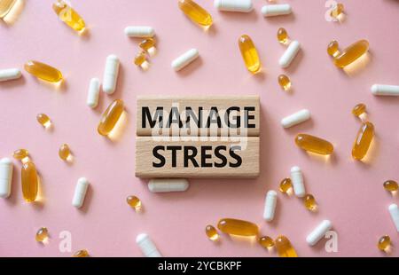 Manage stress symbol. Concept word Manage stress on wooden blocks. Beautiful pink background with pills. Medicine and Manage stress concept. Copy spac Stock Photo