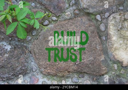 Build trust symbol. Stone wall with words Build trust. Beautiful stone background. Business and Build trust concept. Copy space. Stock Photo