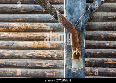 Old Rusty Lock on Weathered Wooden Log Cabin Wall Stock Photo