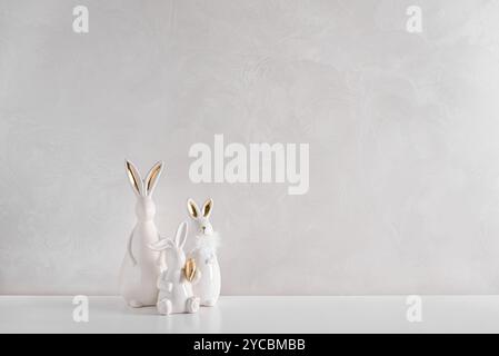 Three Easter rabbits figurines on white background. Easter celebration concept. Copy space. Front view Stock Photo