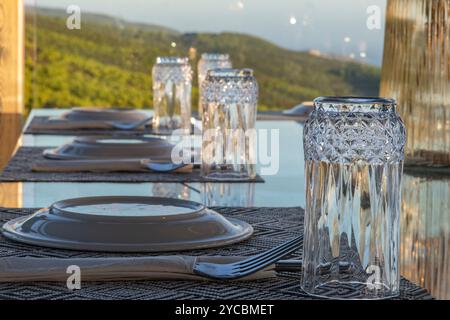 restaurant tables set for dinner with glasses and plates ready for customers or diners Stock Photo