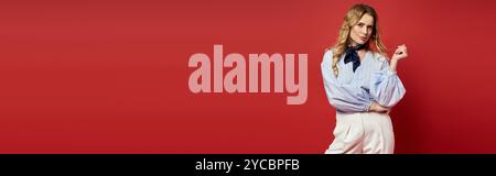 A stylish middle aged person poses against a striking red wall in this creative portrait. Stock Photo