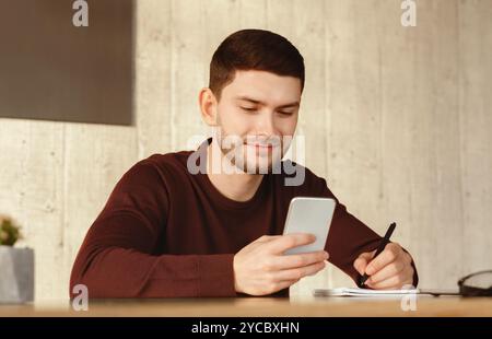 Student Guy Using Smartphone Learning Sitting At Home Stock Photo