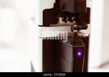 Glasses Manufacturing Process. Optician polishing glasses in optical shop Stock Photo