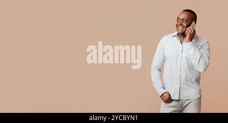 Positive mature afro man talking on cellphone Stock Photo