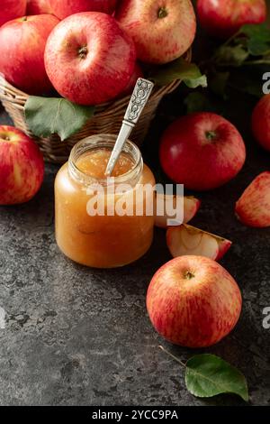 Apple jam and red fresh apples on a black stone table. Stock Photo