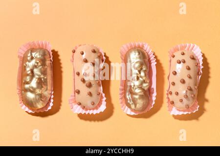Composition with different glazed eclairs on color background Stock Photo