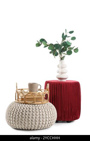 Poufs with branches in vase and cup of drink on tray on white background Stock Photo