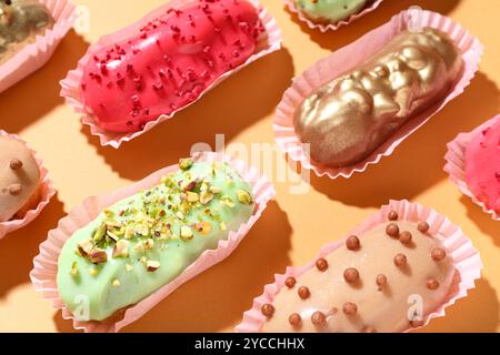 Composition with different glazed eclairs on color background Stock Photo