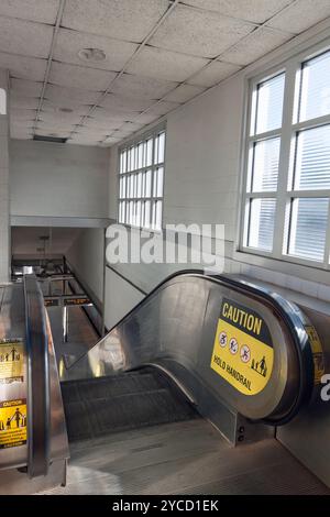 Caution Sign on Handrail of Escalator. Stock Photo