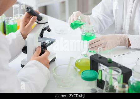 Chemists working at table in laboratory, closeup Stock Photo