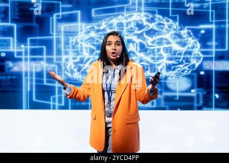 Engineer using mic during presentation, exploring ways emerging AI technologies can enhance businesses workforce. Data researcher at event presents strategies for using artificial intelligence Stock Photo