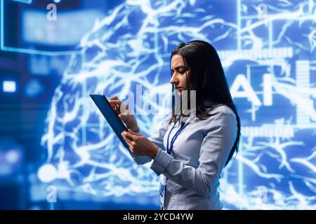 Computer scientist using artificial intelligence computing simulating human brain thought processes. Indian employee working on tablet, developing AI machine learning algorithms Stock Photo