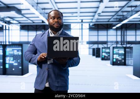 Engineer in data center implementing and managing data backup solutions to protect against data loss and ensuring efficient recovery processes, identifying and resolving technical issues Stock Photo