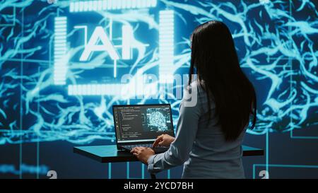 AI specialist reviews data charts, emphasizing importance of data driven decision making in tech industry. Engineer developing innovative artificial intelligence solutions for startup, camera A Stock Photo