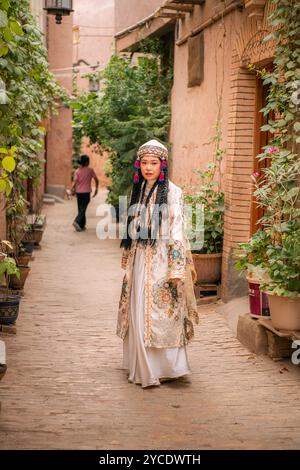 Kashgar, Xinjiang, China - JULY, 17, 2023: A girl wearing Uighur clothes in a scenic street in Kashgar Ancient City Stock Photo