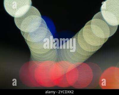 Bokeh of night shot, road, street lights, transportation abstract in city. Beautiful blurry colored lights. Random circular geometry. Horizontal. Stock Photo