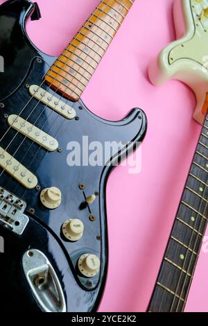 Electric guitar on a pink background, close-up, top view Stock Photo