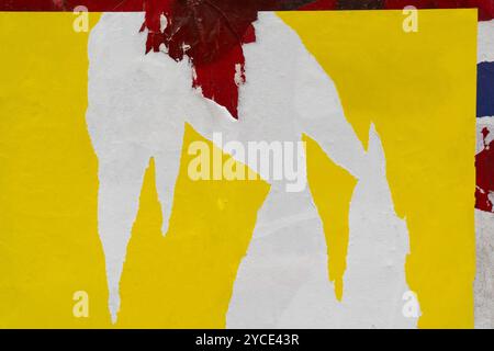 Peeled yellow paper poster on a red wall Stock Photo