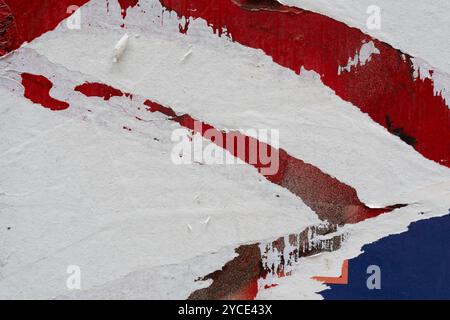 Peeled red paper poster on a wall Stock Photo