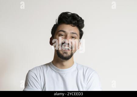 Portrait of a young man with braces smiling and laughing. A happy young man with braces on a white background Stock Photo
