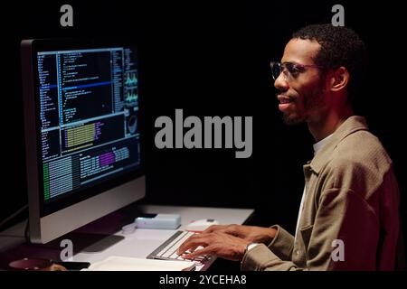 Focused Programmer Analyzing Code on Computer Screen Stock Photo