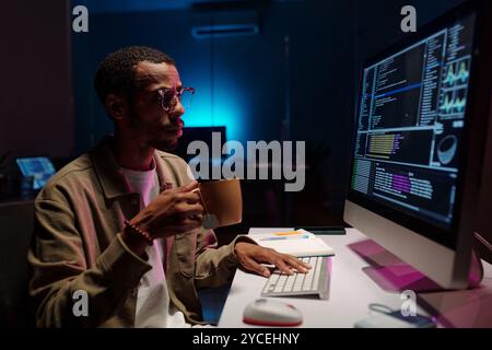 Coding at Night in Modern Office Environment Stock Photo