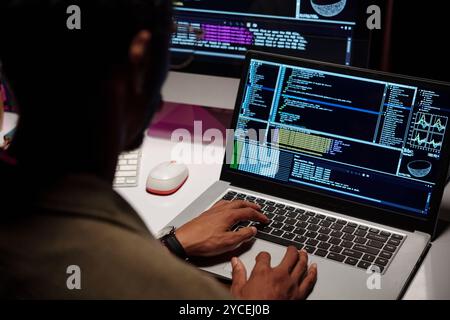 Programmer Analyzing Data on Multiple Screens Stock Photo