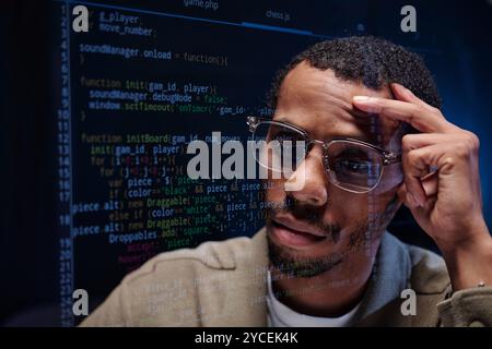 Analyzing Code on Computer Screen with Serious Expression Stock Photo