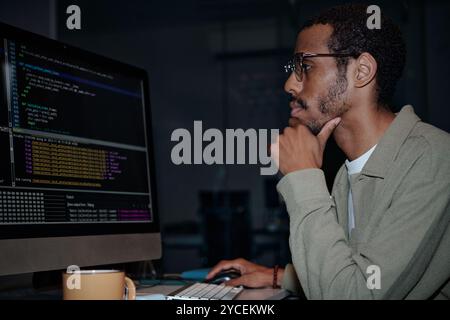 Focused Programmer Working on Code at Computer Stock Photo