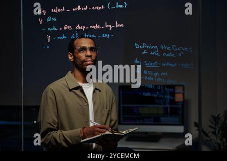 Studying Computer Code Reflected on Glass Surface Stock Photo