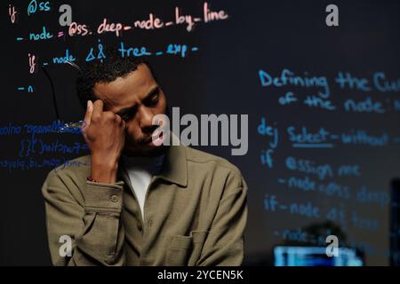 Pensive Developer Reading Code on Transparent Screen Stock Photo