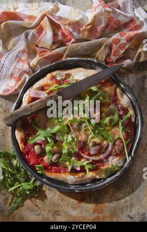 Pizza base with whole wheat flour with arugula and onion Stock Photo