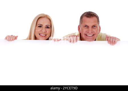 Man and woman holding empty white board and smiling at camera Stock Photo