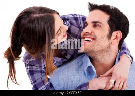 Closeup portrait of a cute young woman hugging her husband from behind Stock Photo