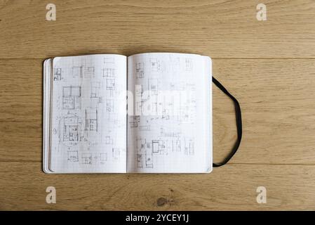 Architect notebook with drawings and sketches on wooden table Stock Photo