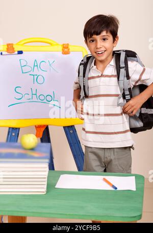 Schoolboy with books and backpack Stock Photo