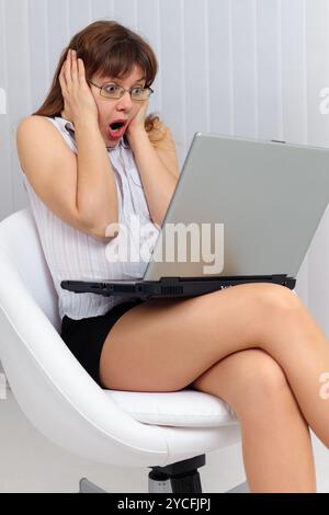 Young woman is shocked by what he saw in Internet Stock Photo