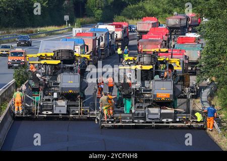 Essen, North Rhine-Westphalia, Germany, Road construction, asphalt pavers and road rollers are laying new, open-pored, whisper asphalt on the A52 high Stock Photo