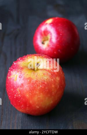 Pair of fresh ripe red apple isolated on black wooden background Stock Photo