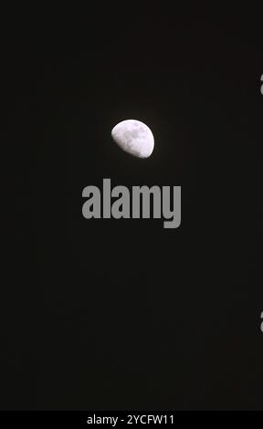 Bright waxing gibbous moon floating on night sky Stock Photo