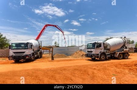 a boom concrete pump and a concrete mixer truck on construction site Stock Photo