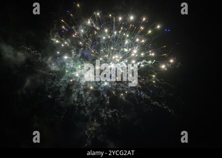 Gold silver fireworks on black background. Abstract firework background with free space for text. Fireworks light up the night sky. Stock Photo